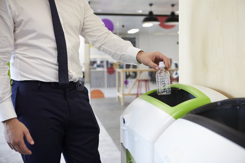 Man i en plast- flaska för kontorsåtervinning, slut upp royaltyfria bilder Man i en plast- flaska för kontorsåtervinning, slut upp royaltyfria bilder