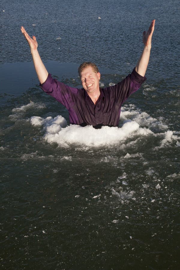 Man in ice hole hands up smile