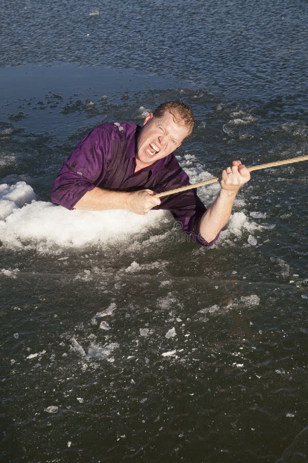 Man in ice hole pull out on rope looking