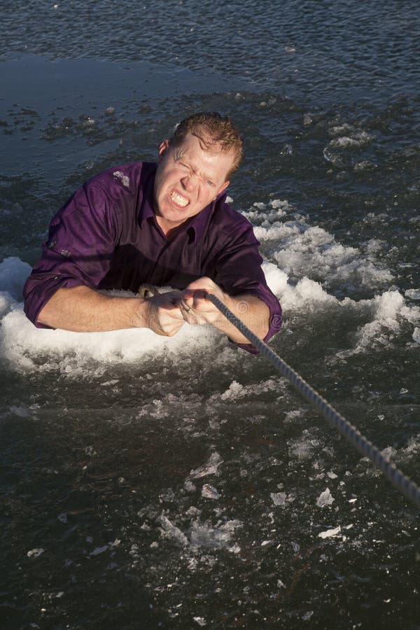 Man in ice hole pull out on rope work hard