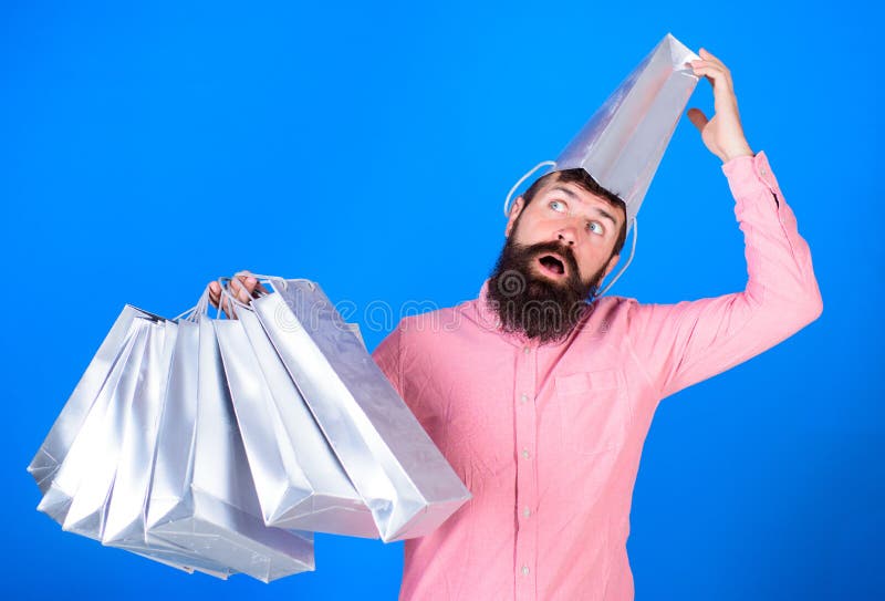 Man with insane look and open mouth wearing silver paper bag on his head. Shopaholic going crazy about seasonal sales royalty free stock images Man with insane look and open mouth wearing silver paper bag on his head. Shopaholic going crazy about seasonal sales royalty free stock images