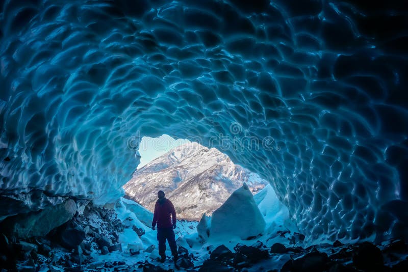 Man inside an ice cave royalty free stock images