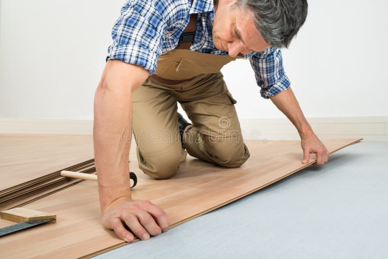 Man installing new laminated wooden floor royalty free stock photography