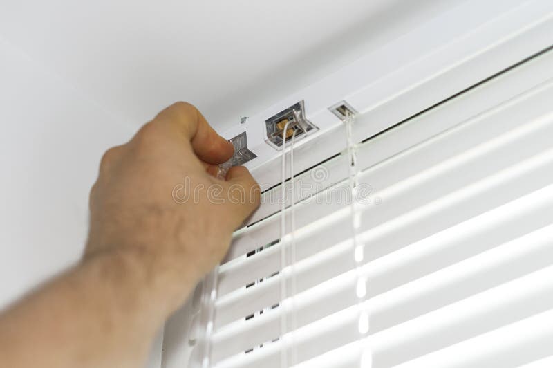 Man installing venetian blinds. stock images