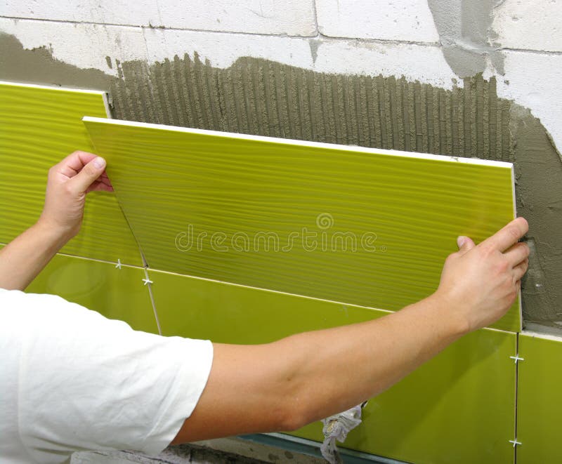 Ceramic Tiles. Tiler Placing Ceramic Wall Tile In Position Over Stock