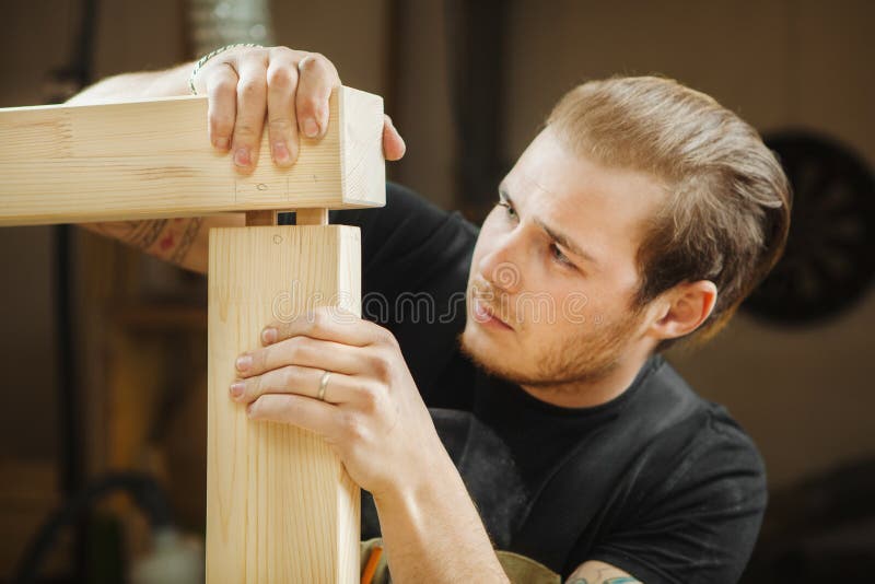 Man joining two parts of wooden planks. Worker carpenter joiner royalty free stock image Man joining two parts of wooden planks. Worker carpenter joiner royalty free stock image