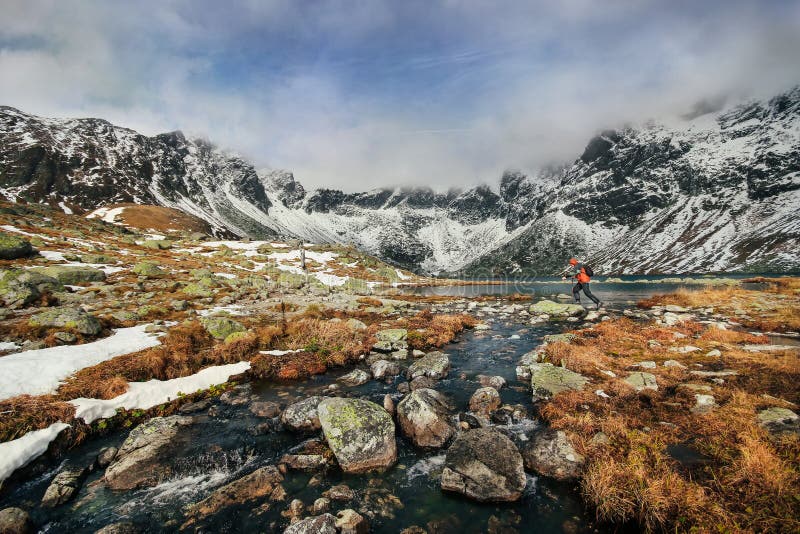 A man jumping across rocks over a lake in the High Tatras