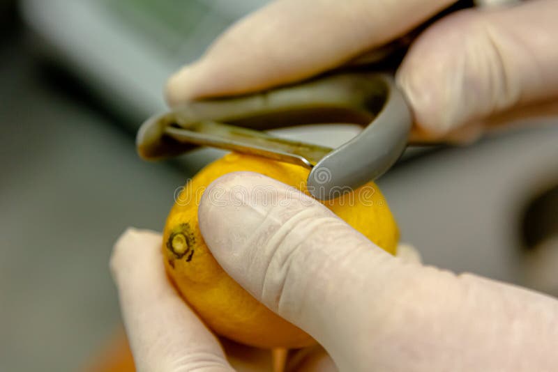 Man in the Kitchen Grating Lemon Zest into a Dressing Stock Photo