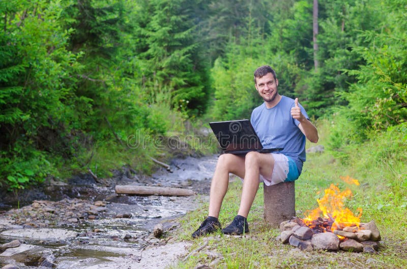 Man with laptop shows sign ok, free space. Businessman working o