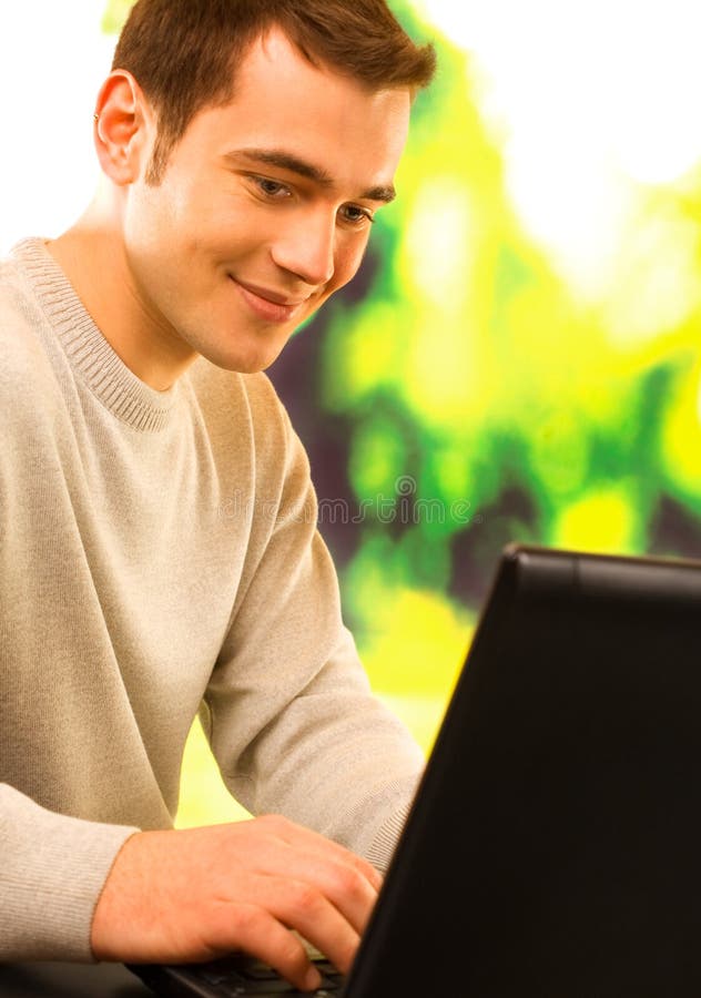 Young attractive happy smiling man on laptop, working, chatting or walking at the net