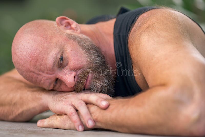 Man laying his head on his arms at the table