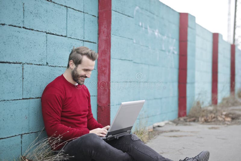 Man Leaning Against Wall Using Laptop Picture. Image 112455151