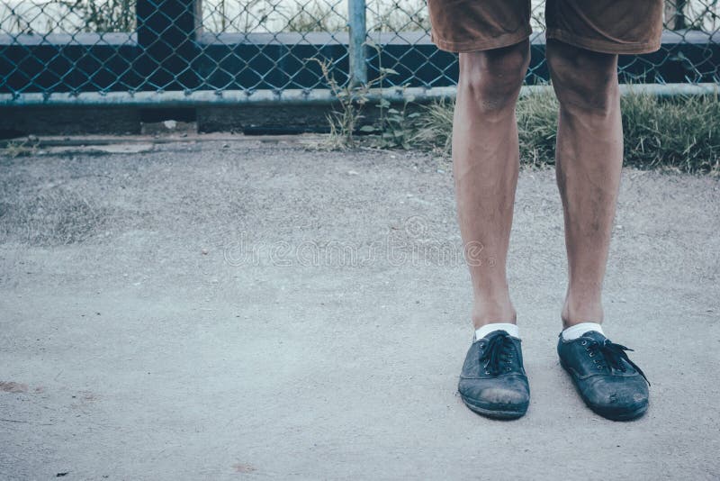 A Man Legs Wearing Black Canvas Shoes And Brown Pants Standing On ...