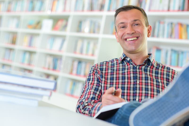 Man in library with feet on table royalty free stock image