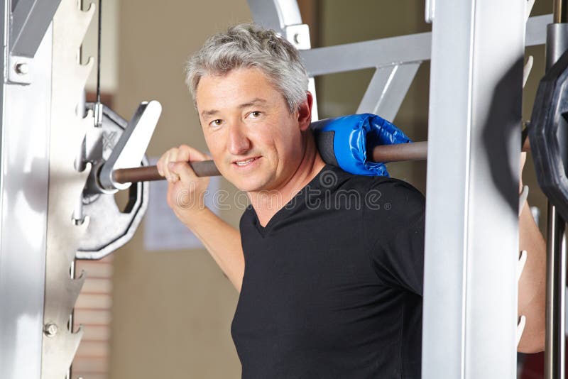 Man lifting barbell in fitness center as part of his gym training