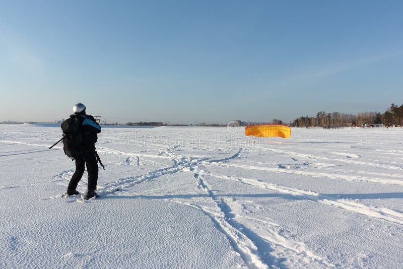 Man Man Lifting a Kite from the Snowy Surface of a Reservoir, Novosibirsk, Russia Stock Image