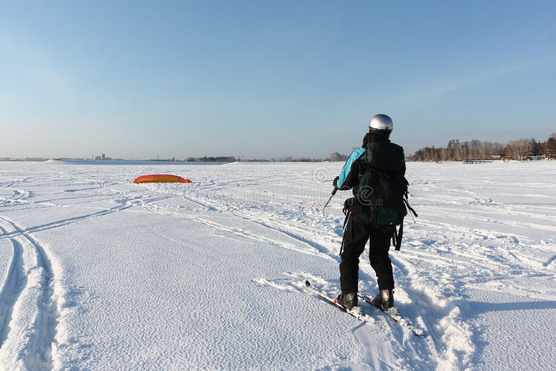 Man Man Lifting a Kite from the Snowy Surface of a Reservoir, Novosibirsk, Russia Stock Photo