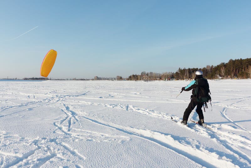 Man Man Lifting a Kite from the Snowy Surface of a Reservoir, Novosibirsk, Russia Stock Image