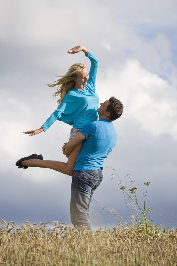 Man lifting woman in countryside