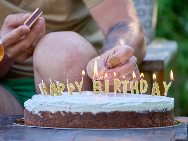 Man Lighting Birthday Candles with a Match Stock Photo Image of cream