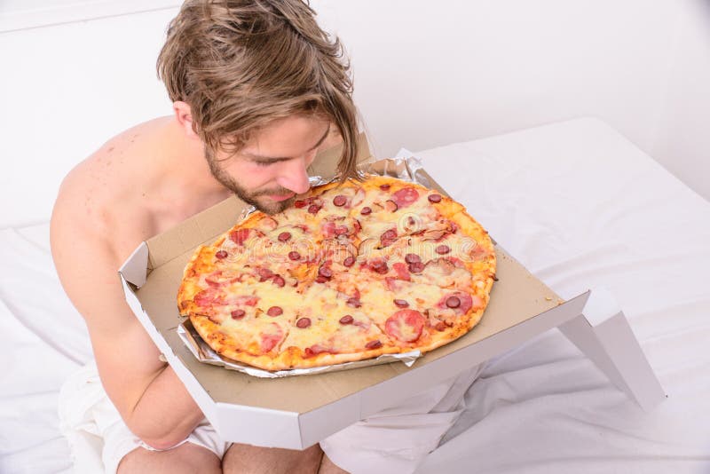 Man bearded handsome guy eating cheesy food for breakfast in bed stock phot...