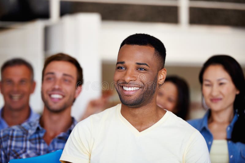 Man, listening and smile with crowd in office for presentation, training or workshop at media company. Person, attention stock photo