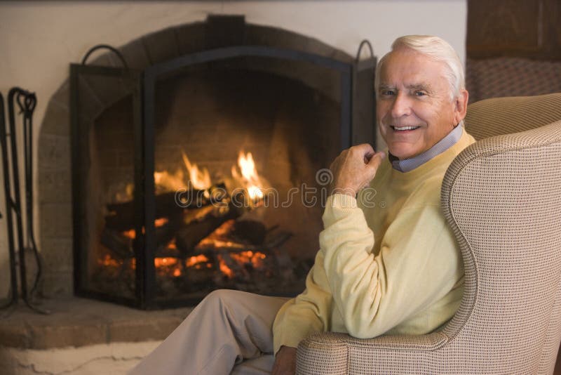 Man in living room by the fireplace smiling at camera