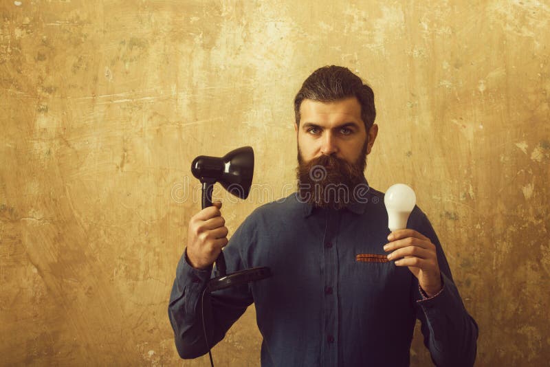 Man with long beard hold lamp and bulb