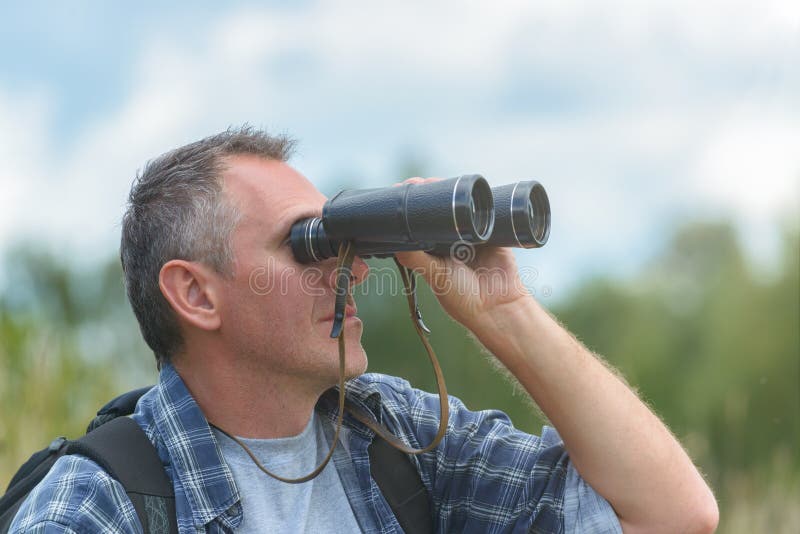 Man looking through binocular stock images
