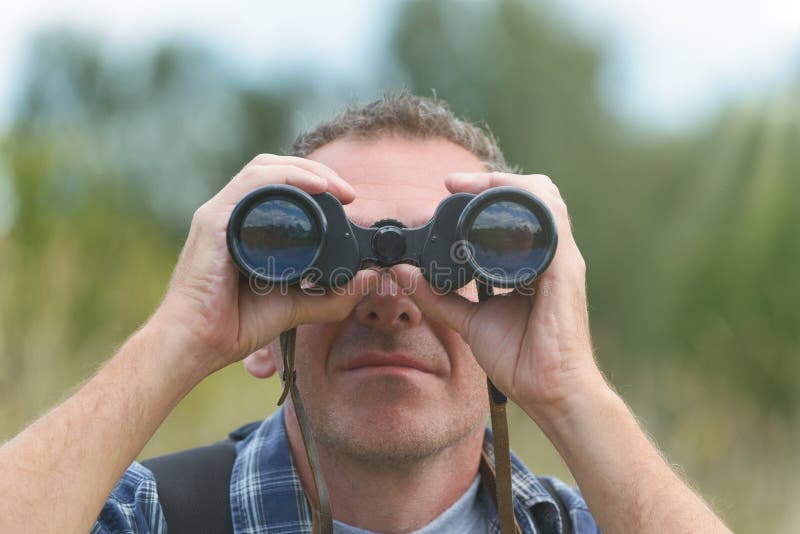 Man looking through binocular stock image