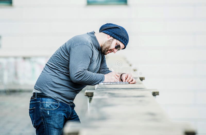 Man looking at his notebook and writing something