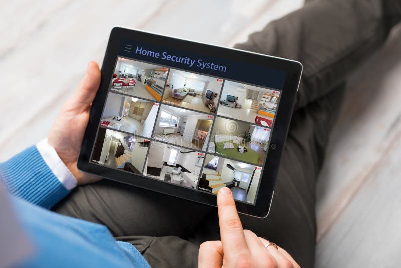 Man looking at home security cameras on tablet computer royalty free stock image