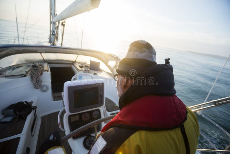 Man Looking At Navigational Screen On Sail Boat