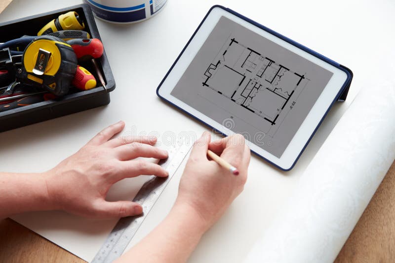 Man Looking At Room Plans On Digital Tablet