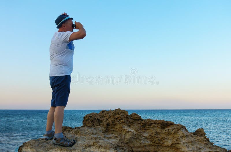 Man looks through a telescope at the sea royalty free stock photo