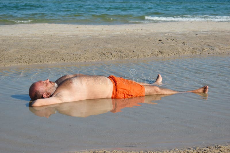 The Man in the Puddle on the Beach. Relaxing Holiday by the Sea. Fun Beach  Photo. the Fat Man in the Sea Stock Image - Image of large, lying: 171809171