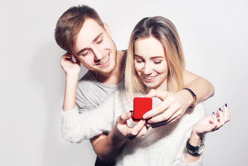 Man makes present to his lovely sweetheart girl. Young man giving a gift. Couple offering to each other gifts for lover`s