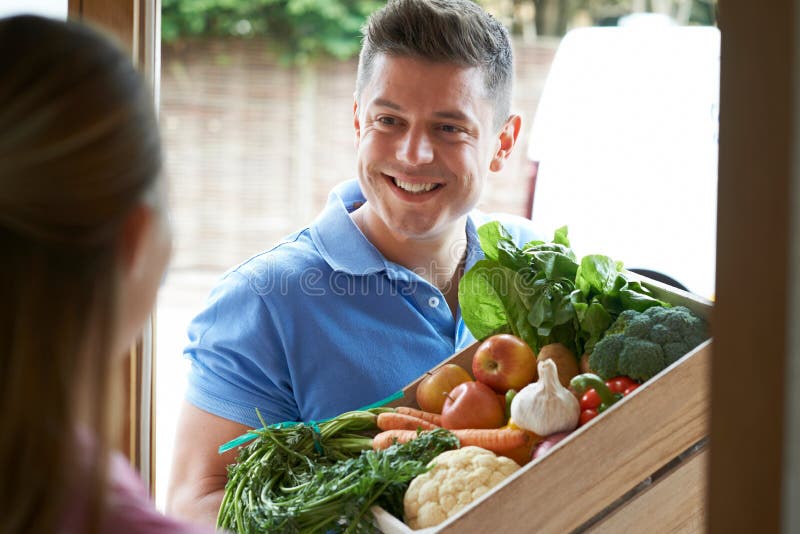 Man Making Home Delivery Of Organic Vegetable Box stock photos Man Making Home Delivery Of Organic Vegetable Box stock photos