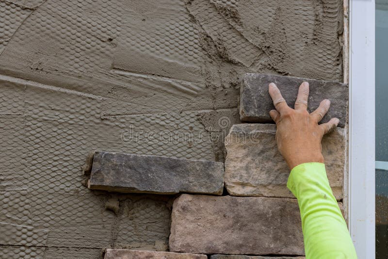 Man Making Texture of Wall Facing with Decorative Stone Tiles Bricks