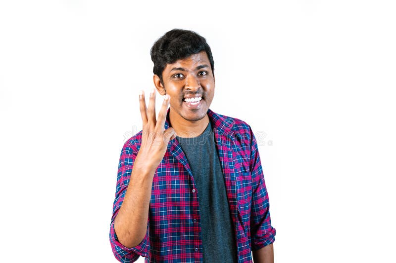 A man is raising his hand with three fingers extended. The background is plain. A man is raising his hand with three fingers extended. The background is plain