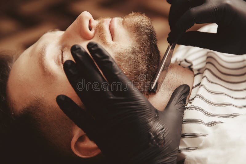 Man in male Barber shop. Wizard makes cut beard with razor royalty free stock images Man in male Barber shop. Wizard makes cut beard with razor royalty free stock images