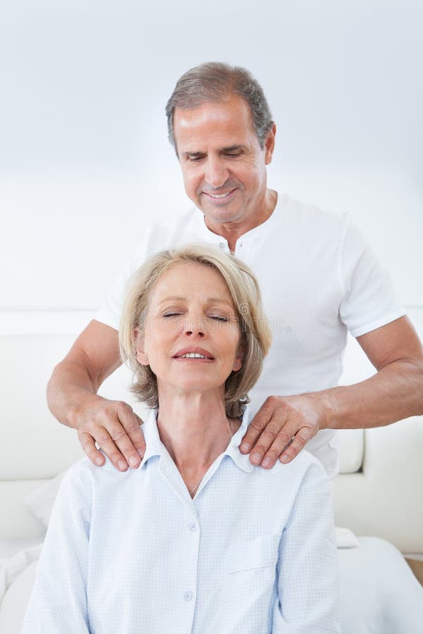Mature Man Massaging Woman's Shoulder In Bed