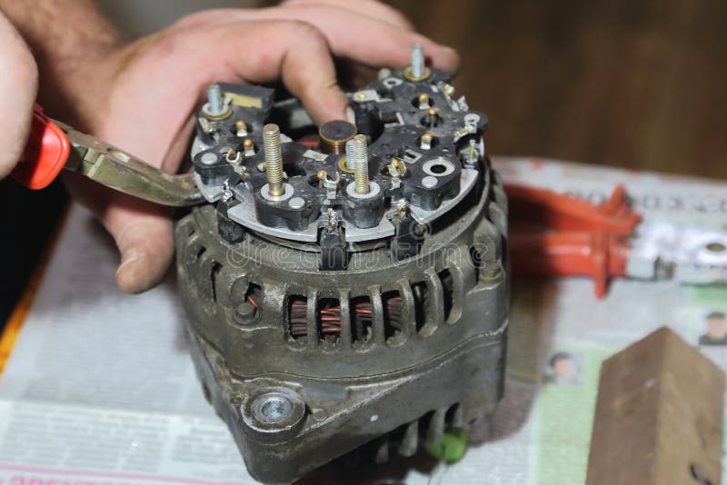The Master Man Repairs the Old Car Generator at Home. Stock Image