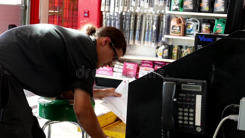 Man Mechanic Taking Car Oil Change Receipt For Customer Stock