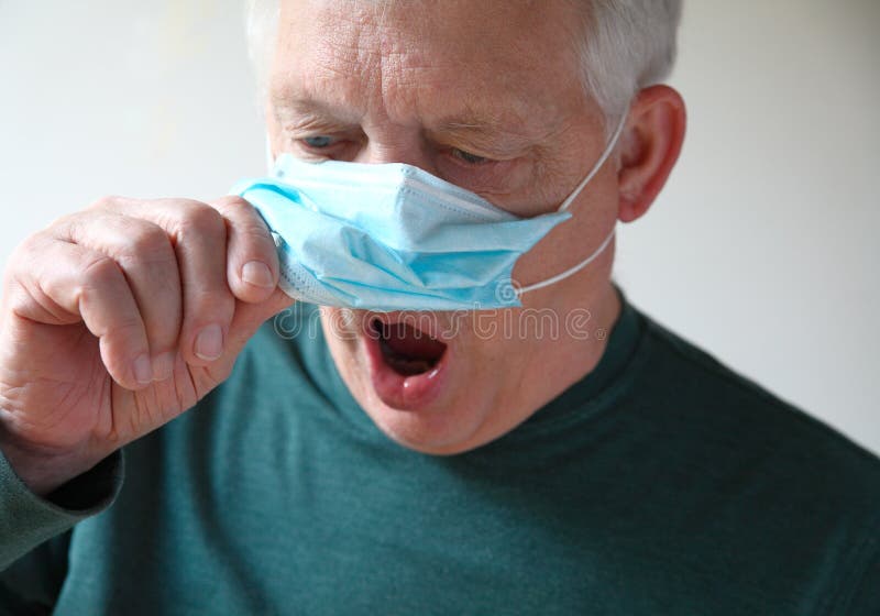 Senior man lifts his medical mask to gasp for air. Senior man lifts his medical mask to gasp for air