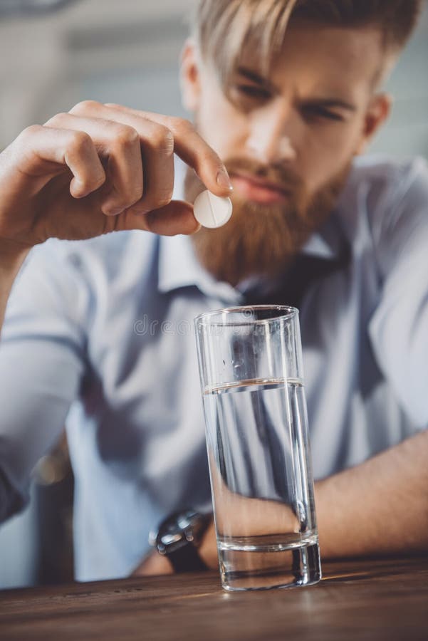 Man med bakrus med mediciner i smutsigt rum fotografering för bildbyråer Man med bakrus med mediciner i smutsigt rum fotografering för bildbyråer