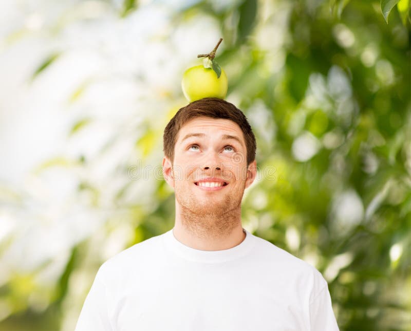 Happy young man with green apple on his head. Happy young man with green apple on his head