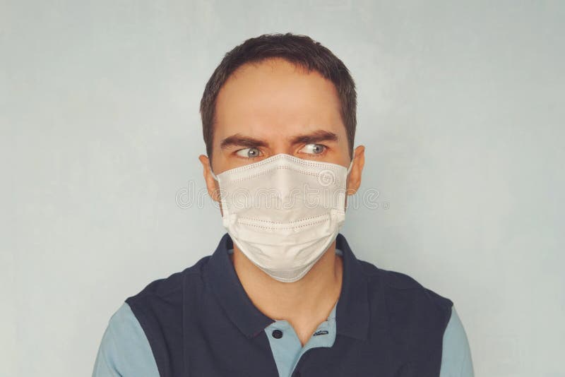 Man in medical mask blue background. quarantine. Young handsome guy in a doctor mask. Epidemiological situation. Protection against pathogenic microbes and rotovirus infections. Man in medical mask blue background. quarantine. Young handsome guy in a doctor mask. Epidemiological situation. Protection against pathogenic microbes and rotovirus infections.