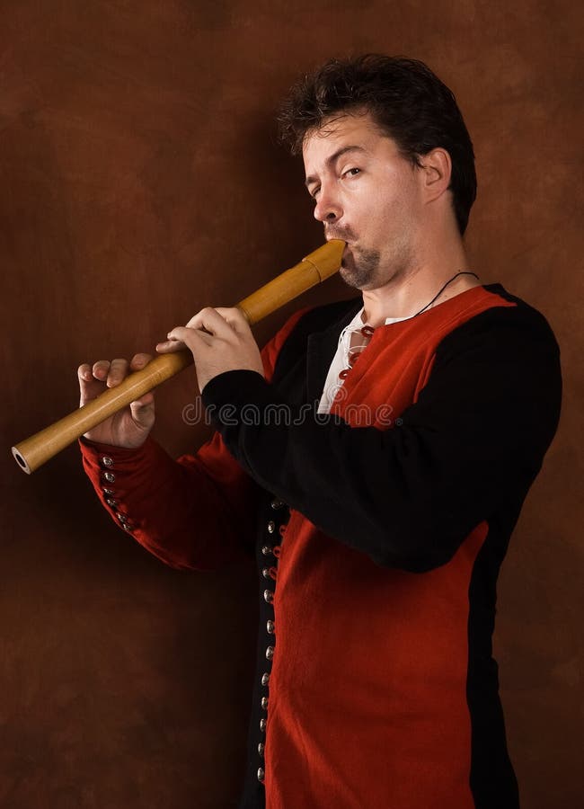 Man in a medieval suit plays a flute