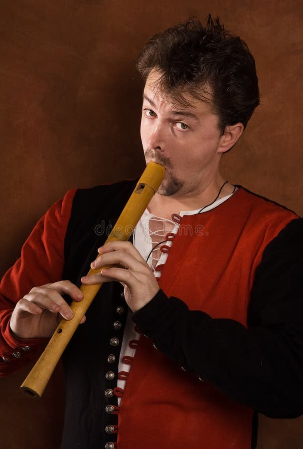 Man in a medieval suit plays a flute